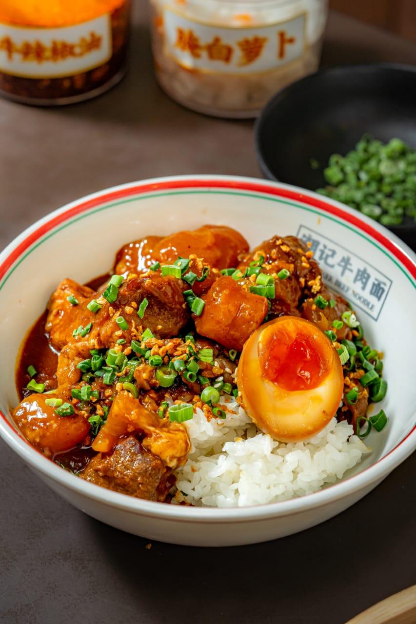 Teowkee braised beef rice bowl with soft-boiled egg and pickled radish condiments