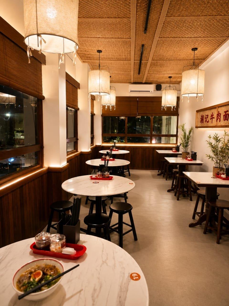 Dining room at the Kuala Lumpur outlet, marble tables under a woven ceiling