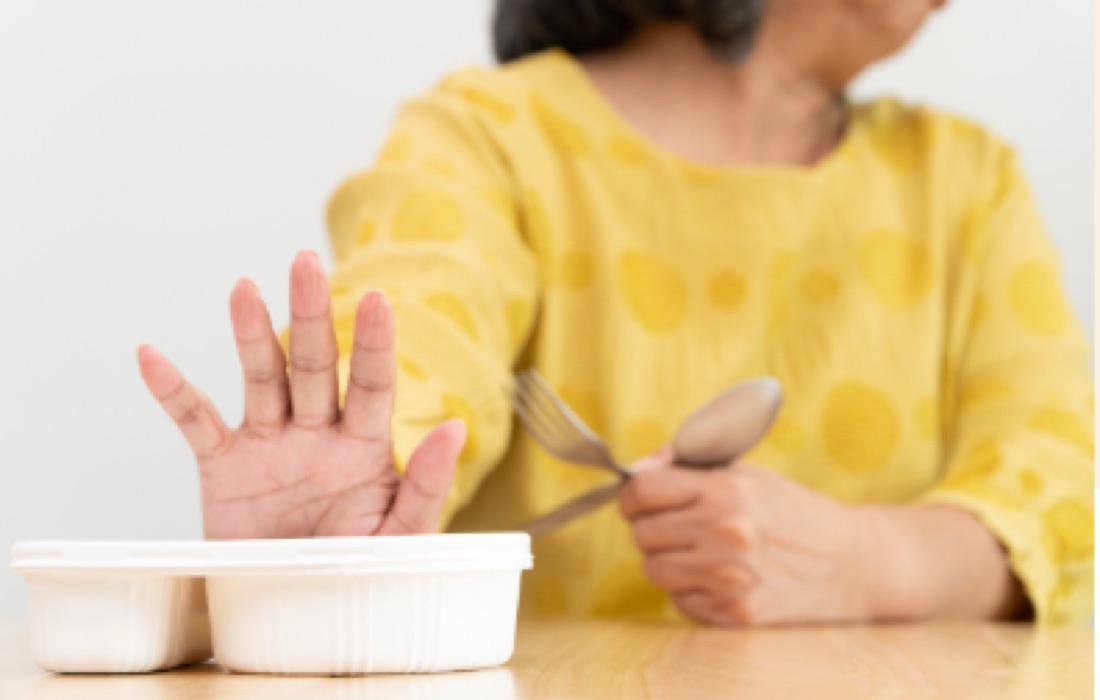 Pushing away a pre-made plastic meal tray